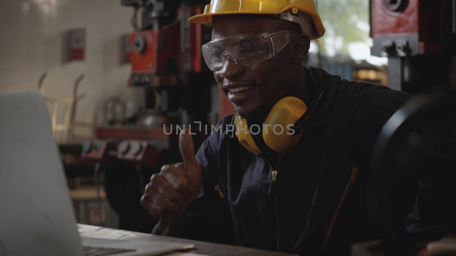 Social distance group of industrial worker, American industrial black young worker man with yellow helmet having teleconference or video conference calls meeting remotely and discussion about project