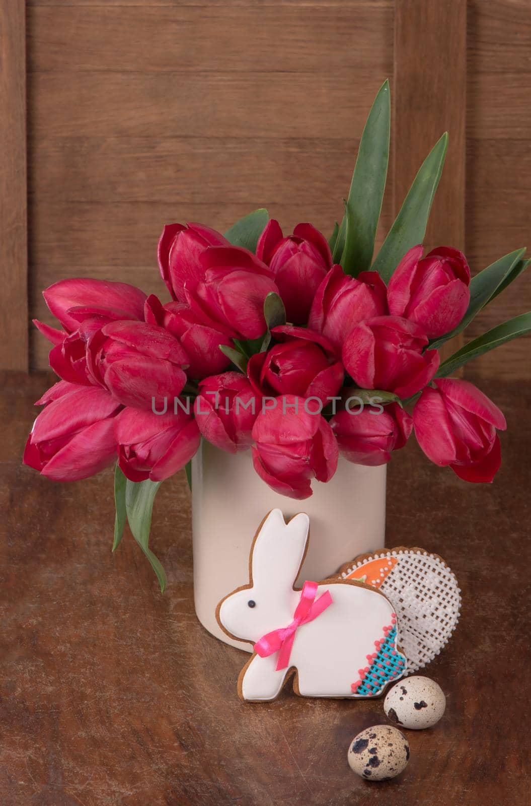 Pink tulips and easter bunny cookie on wooden background. by aprilphoto