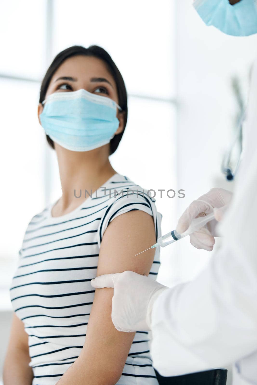 female patient in medical mask making vaccine in hospital. High quality photo