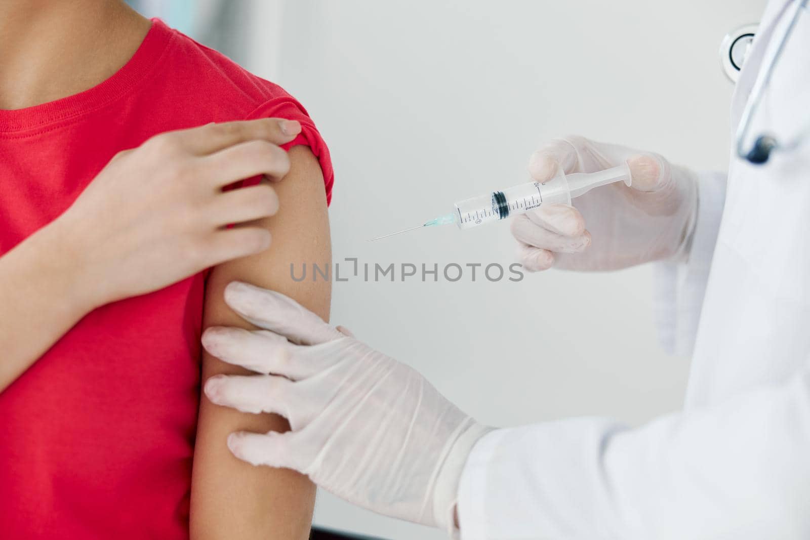 the doctor puts an injection into the patient's hand close-up vaccination by SHOTPRIME