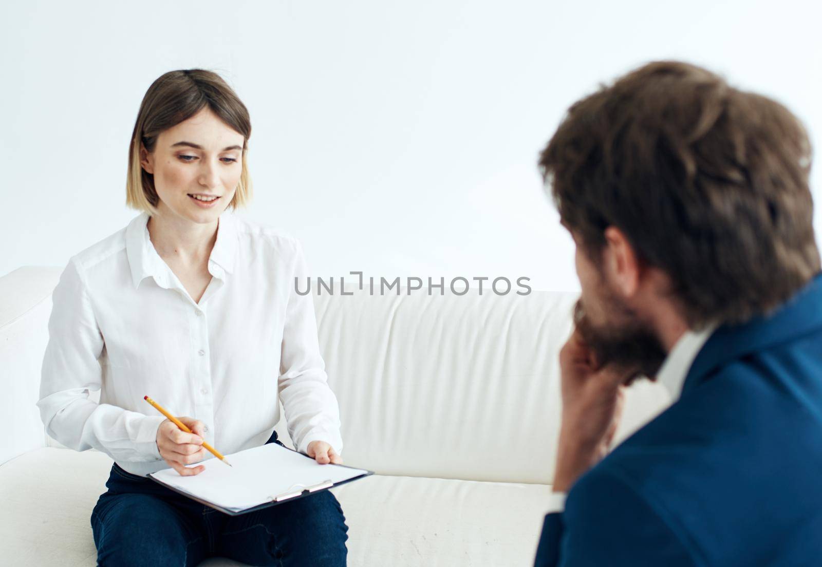 woman with documents and a man in a suit sitting on the couch hiring vacancies. High quality photo