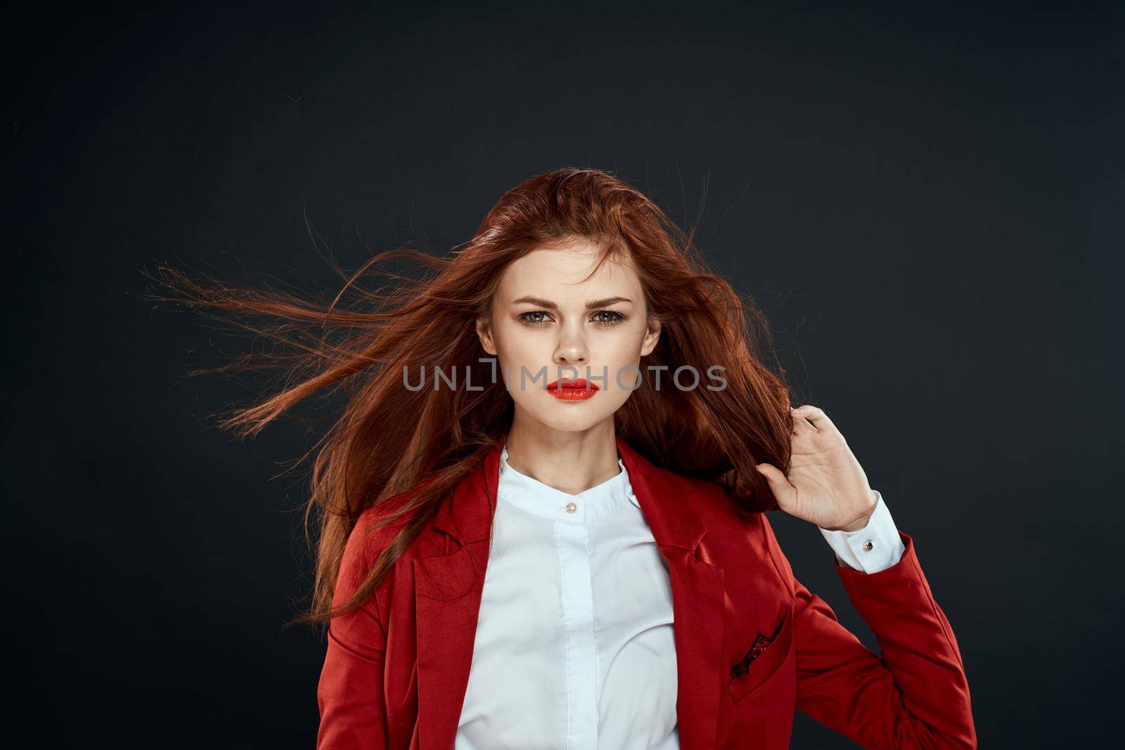 Cute red-haired woman elegant style red jacket black background by SHOTPRIME