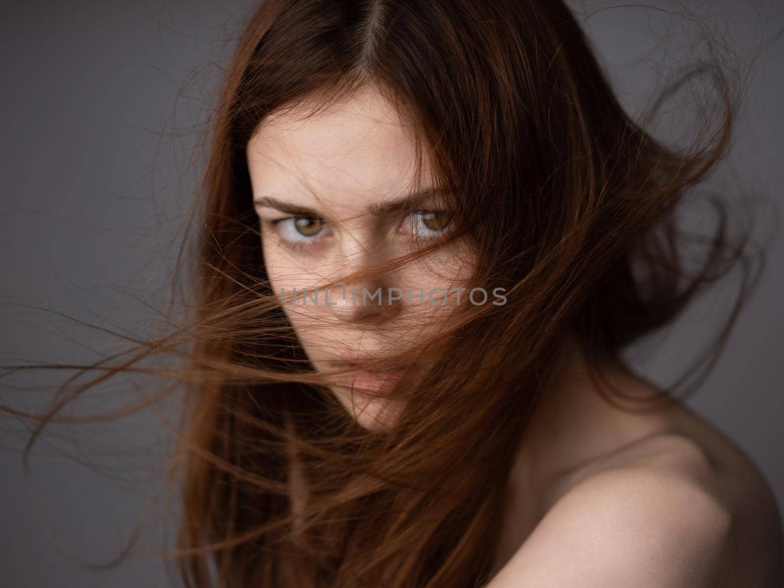 Offended look of a red-haired woman on a gray background bared shoulders close-up by SHOTPRIME