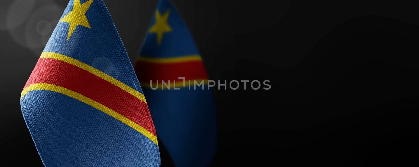 Small national flags of the Democratic Republic of the Congo on a dark background.