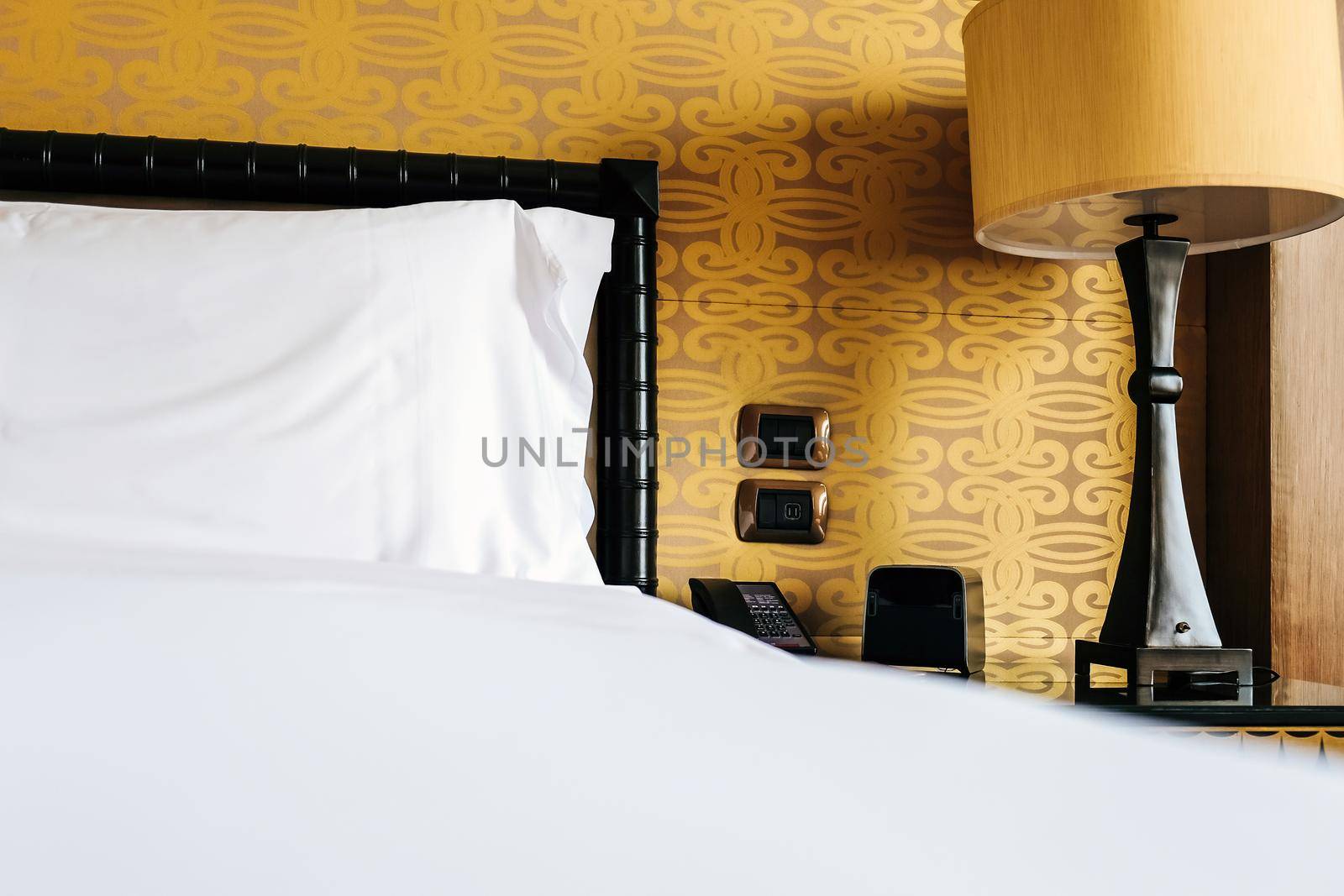 Image of Luxurious bedroom detail, furniture, lamp and accessories.