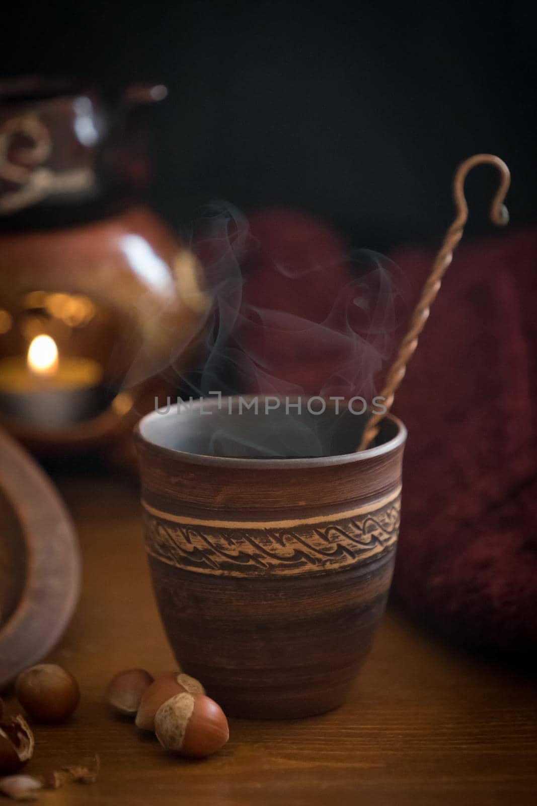 Dark background with a hot drink in a ceramic Cup and the scattered nuts hazelnuts on a wooden surface.