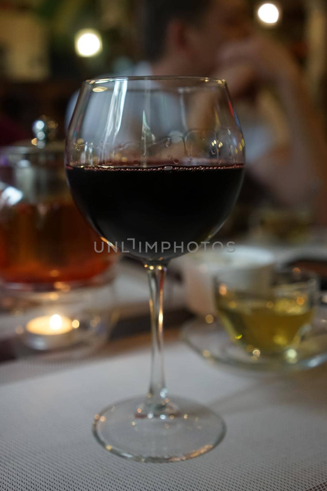 A glass of wine on a blurred background with people.