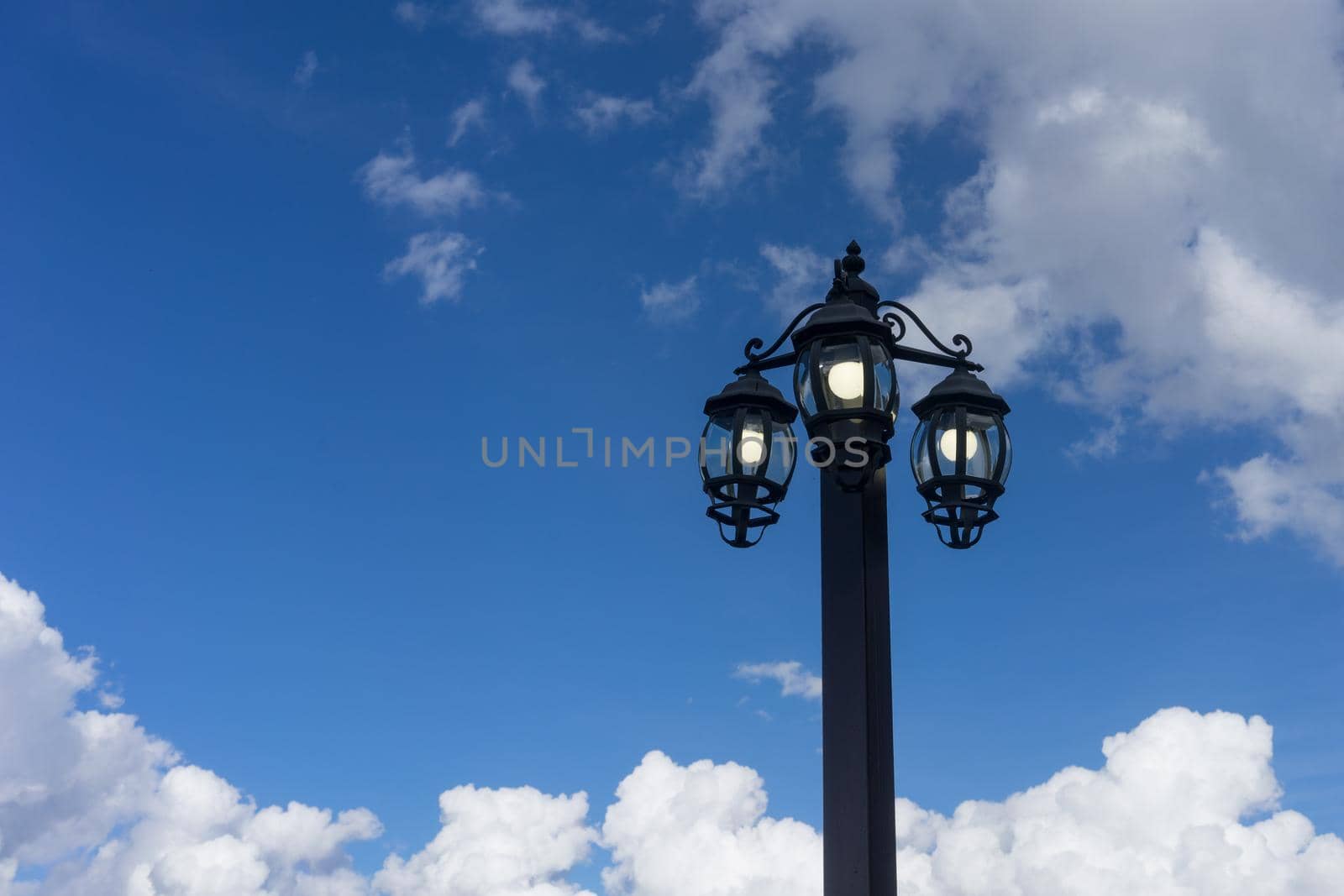 the lantern in the old style on the background of blue sky and clouds in Krasnaya Polyana Soch