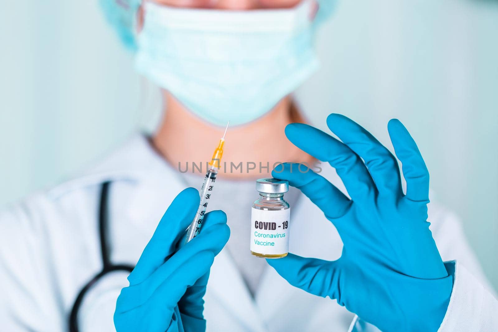 Woman doctor or nurse in uniform and gloves wearing face mask protective in lab, holding medicine vial vaccine bottle with COVID-19 Coronovirus vaccine label