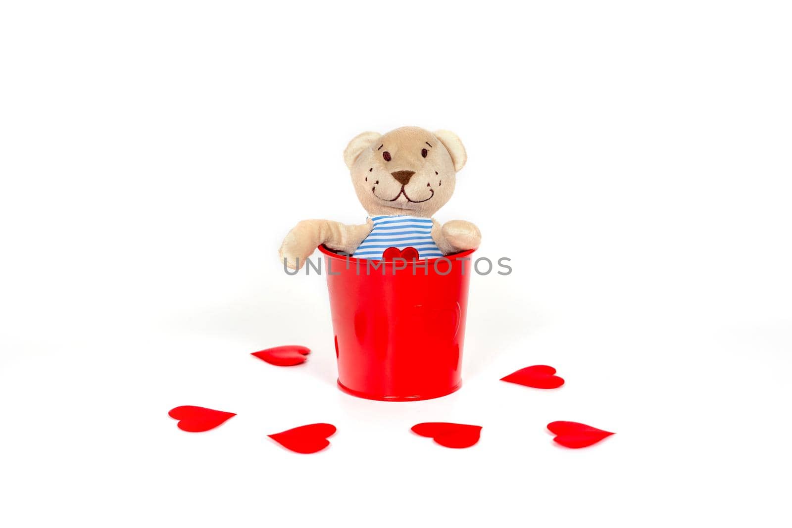 Soft toy bear with an embroidered heart in a red metal bucket on a white by galinasharapova