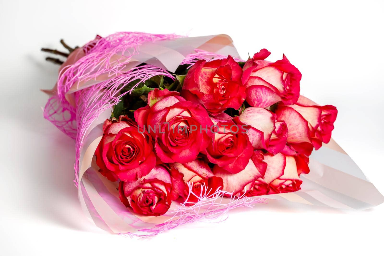 Bouquet of red roses in gift paper packaging on a white background. The concept of a gift to a woman for any event, a symbol of love