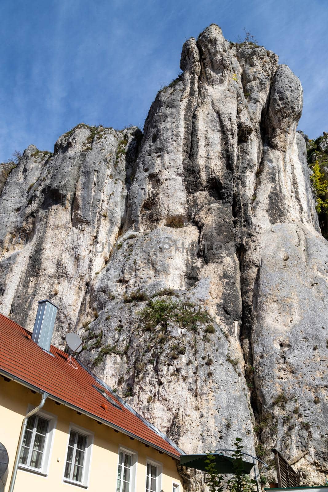 House built directly on the rocks in Essing in Bavaria, Germany at the Altmuehl river on a sunny day in autumn with blue sky and white clouds