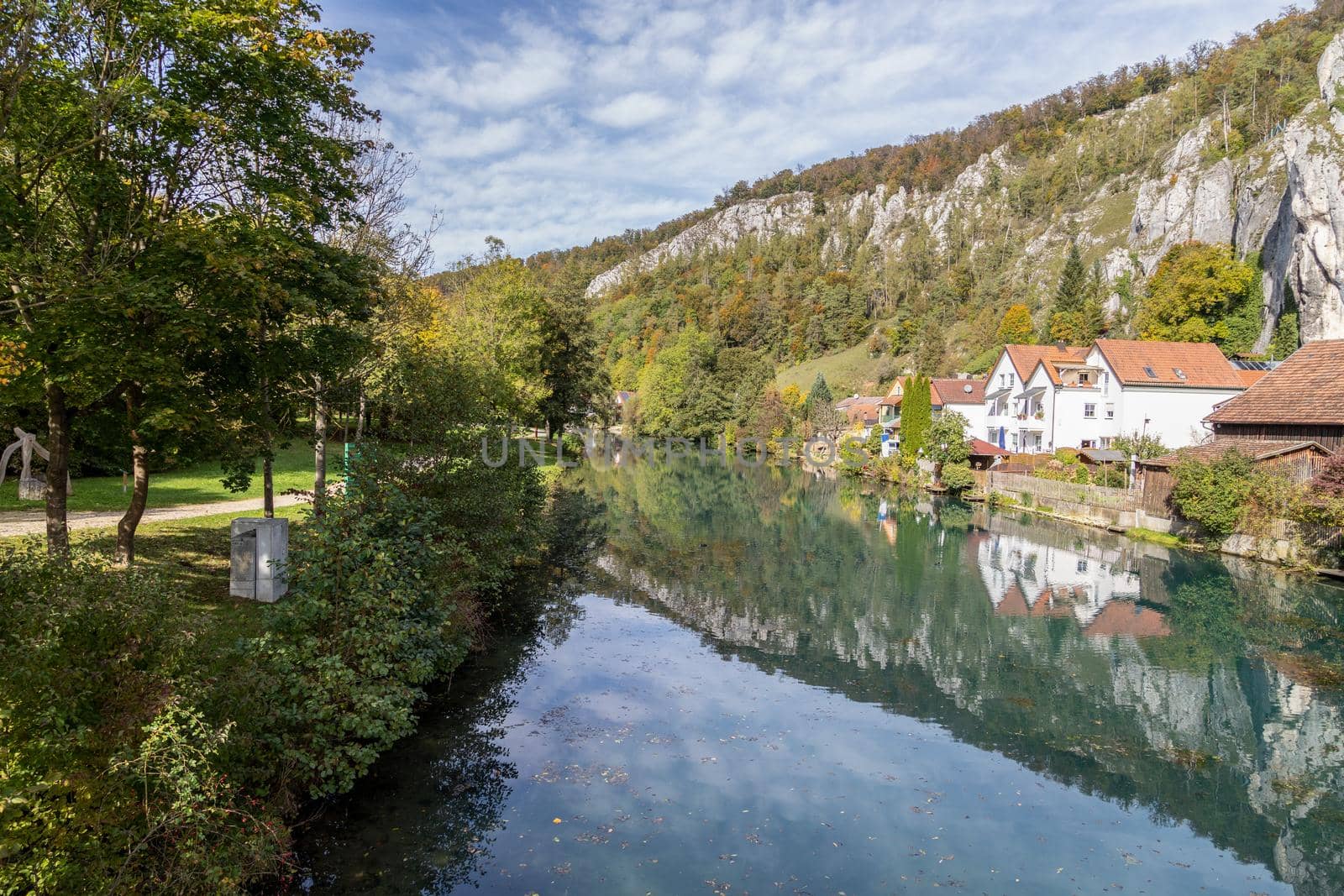 Idyllic view at the village Markt Essing in Bavaria, Germany with the Altmuehl river and high rocks on a sunny day in autumn