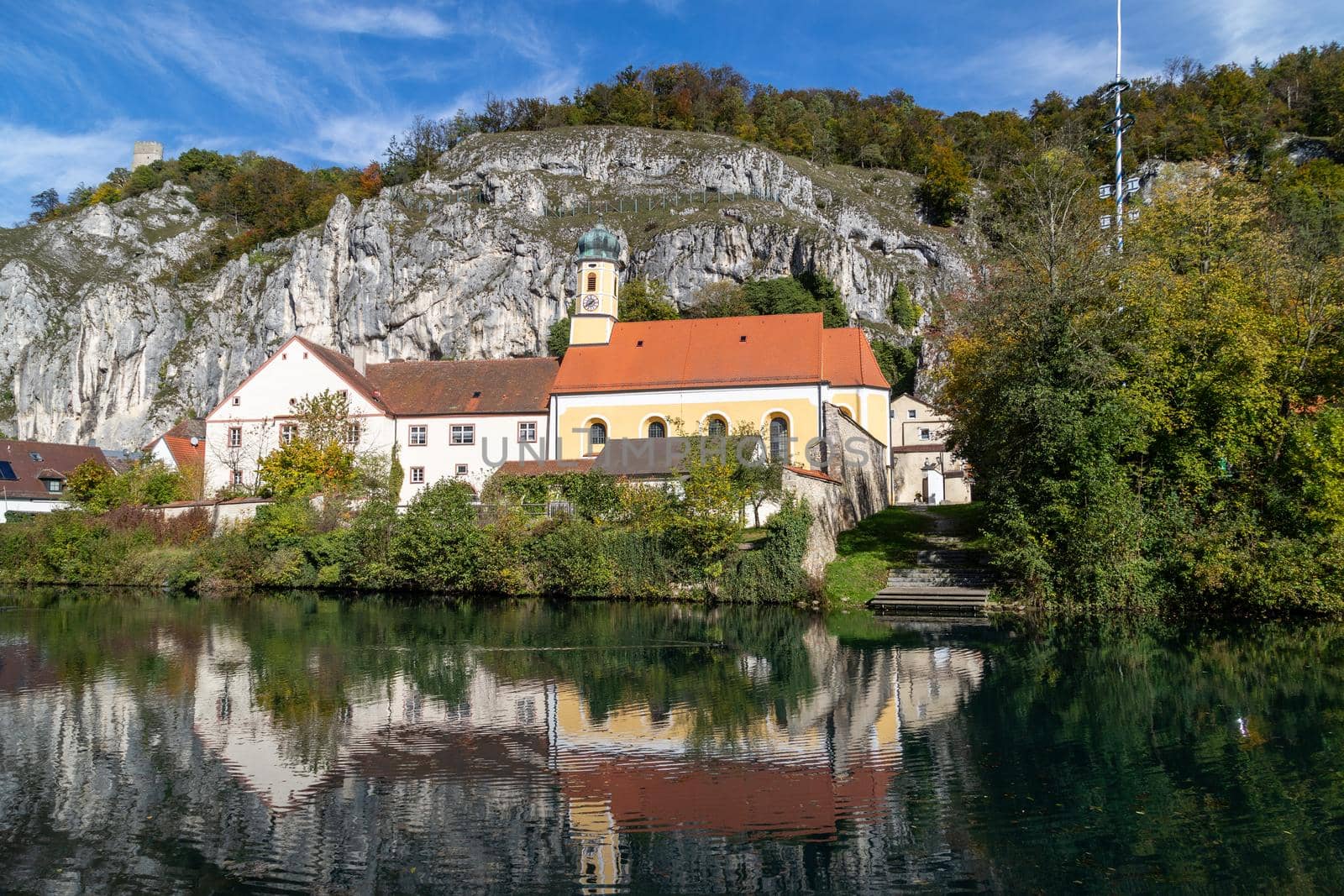 Idyllic view at the village Markt Essing in Bavaria, Germany with the Altmuehl river and high rocks on a sunny day in autumn