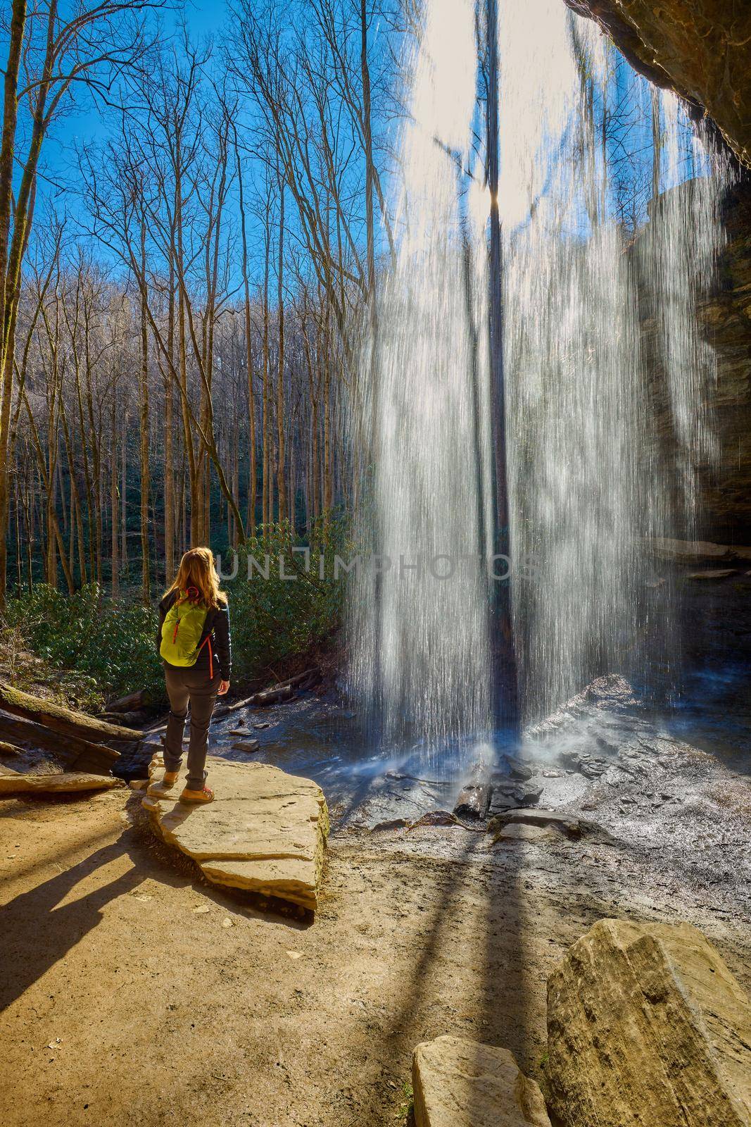 Woman standing near Moore Cove Waterfall in Pisgah National Forest near Brevard NC.