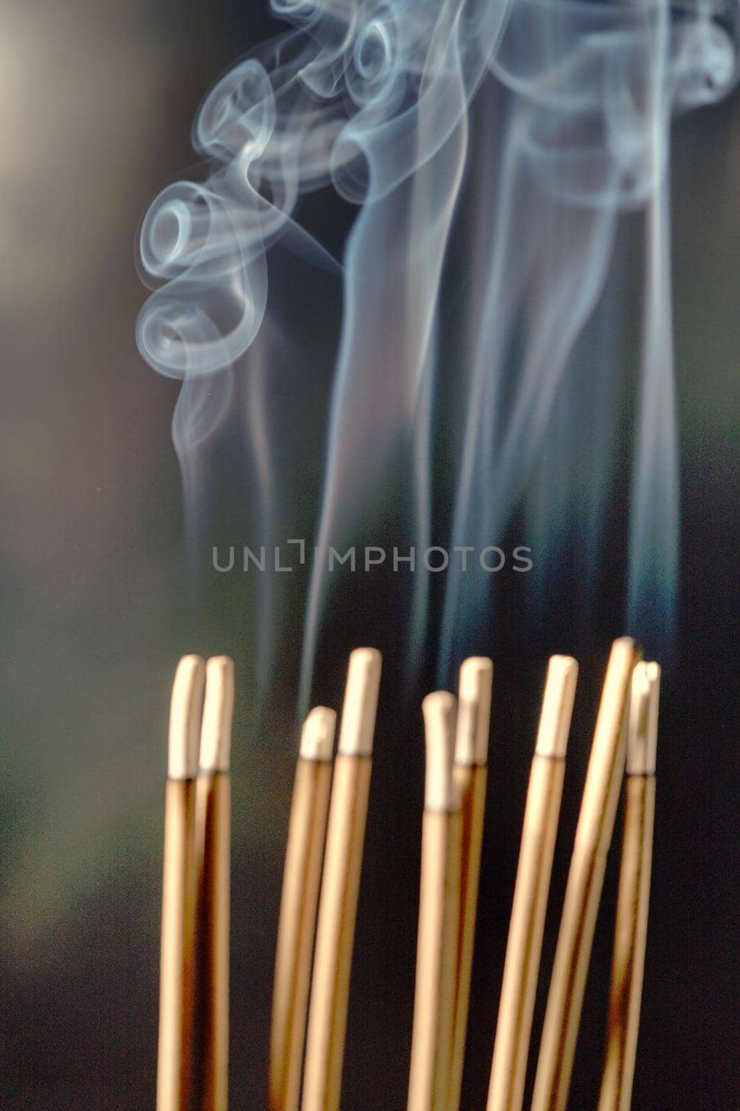 Burning incense, white smoke, black background, used as a worship background image, a sacred object of Buddhist beliefs, focus on the smoke. by noppha80