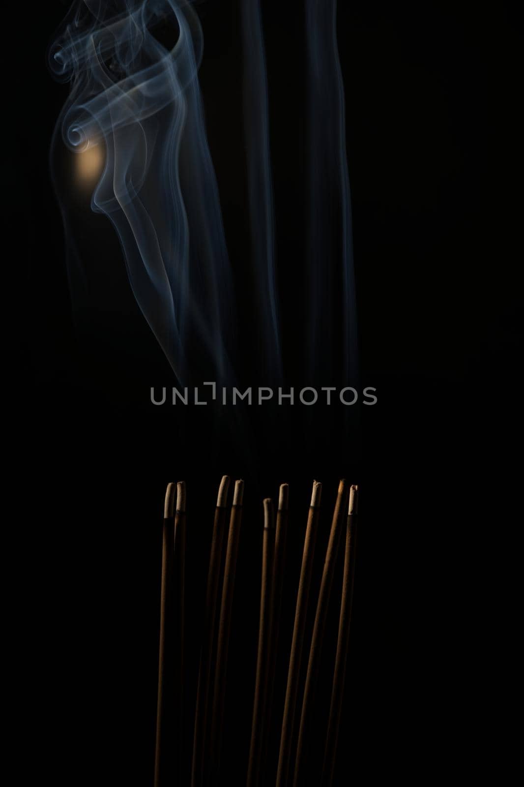 Incense burning incense, white smoke, black background, used as background image Paying homage to the sacred objects of the people of Buddhism according to their beliefs and beliefs.