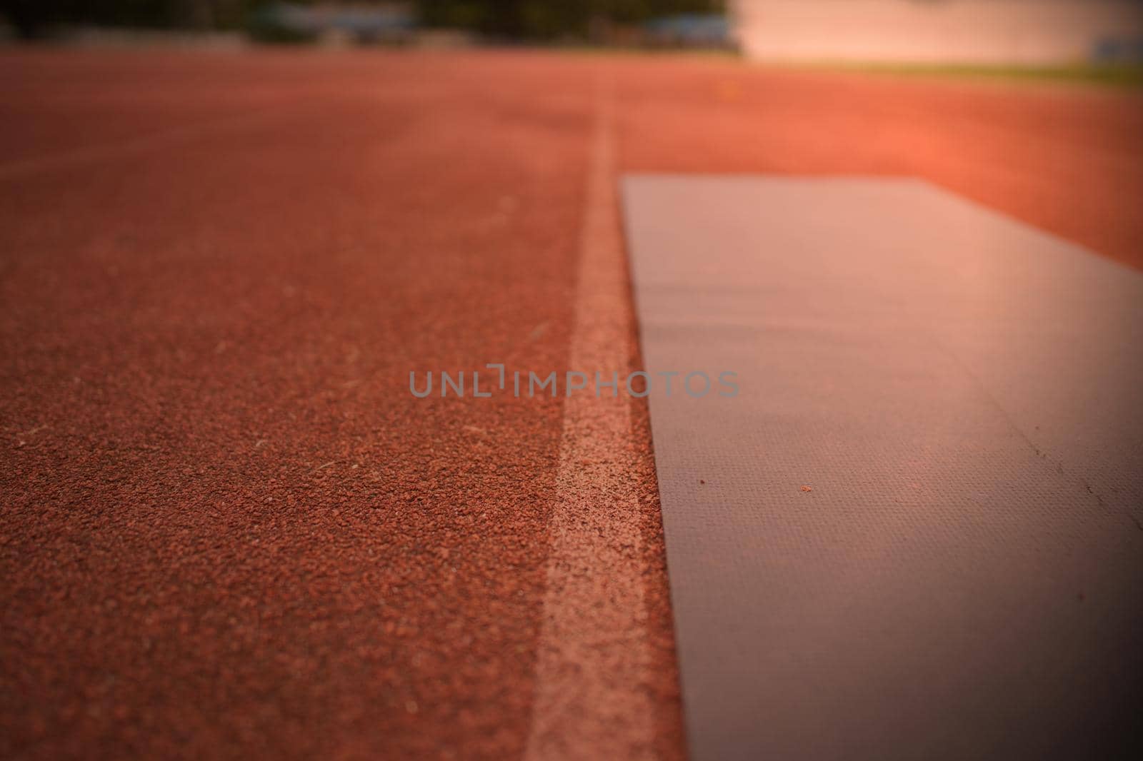 Black yoga mat on the runway of the athletics field, outdoor exercise concept.