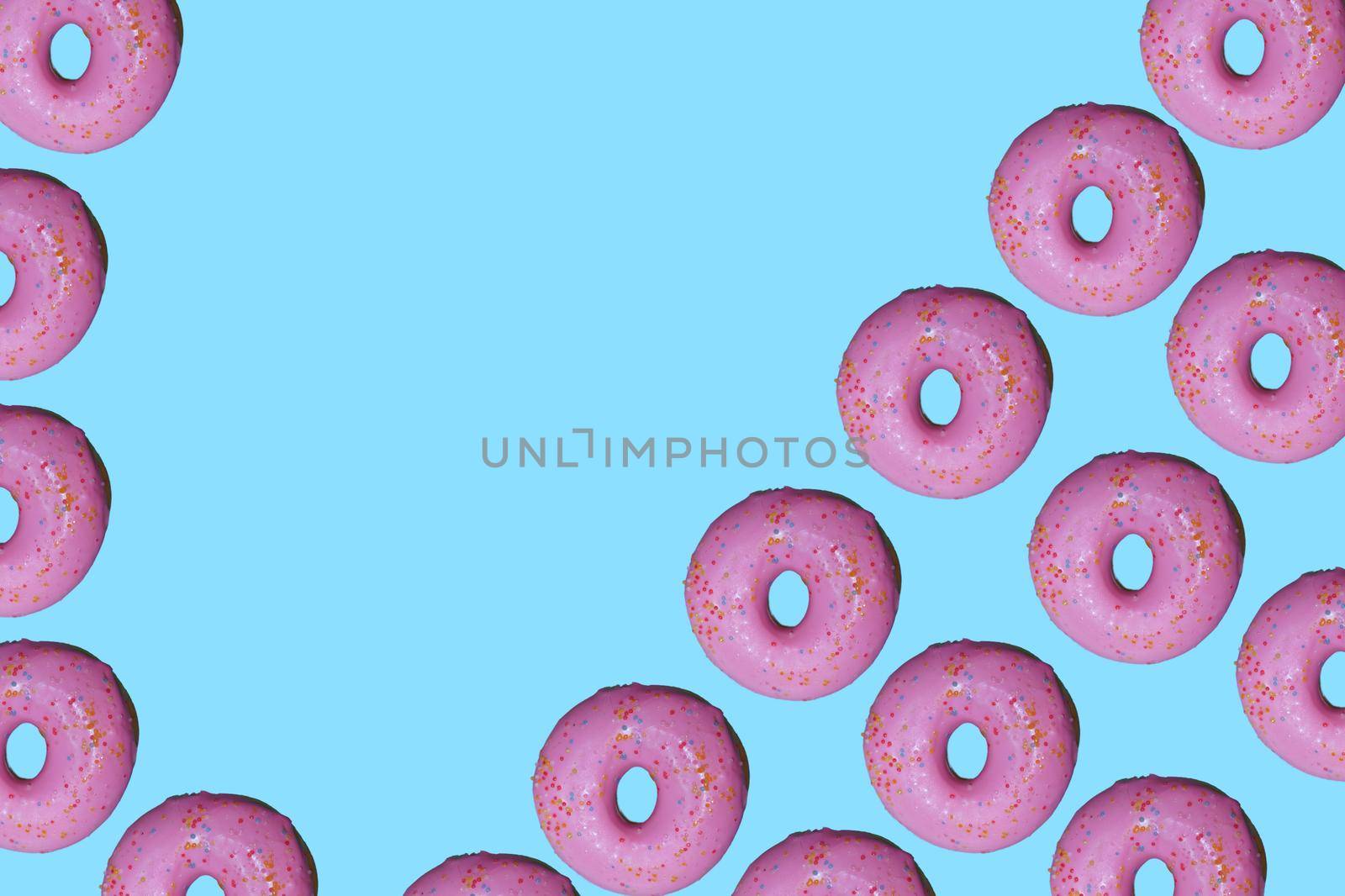 Donut pattern lay flat on top view blue background.