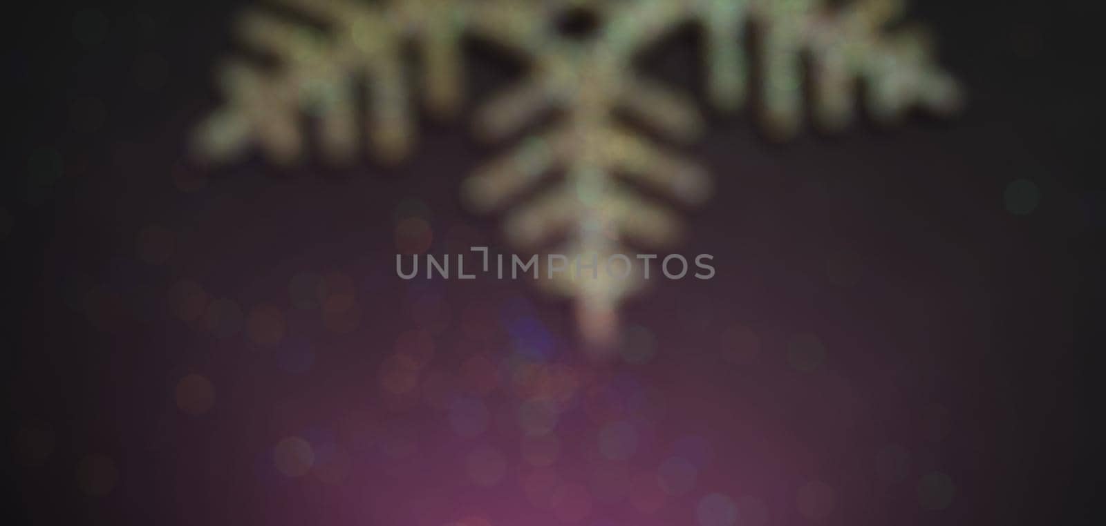 Blurred bokeh elegant christmas background with golden snowflakes shining black wood texture background.
