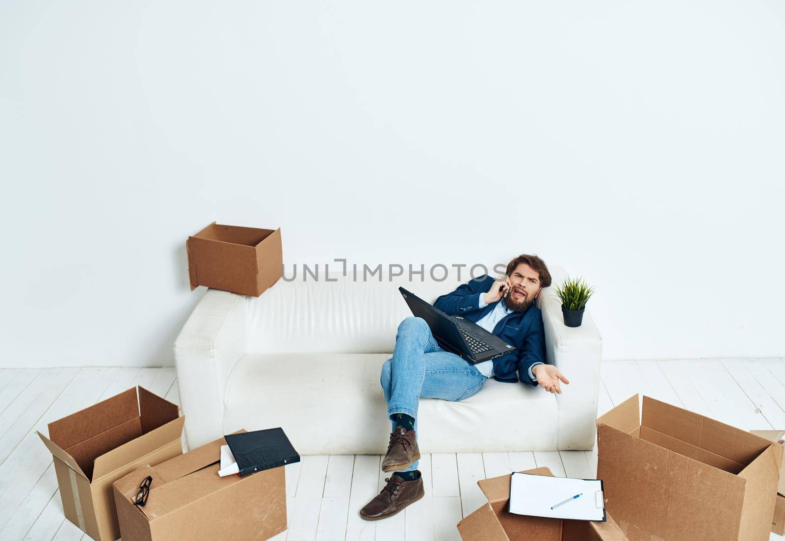 Man in a suit unpacks things emotions office technology lifestyle work in a new place. High quality photo