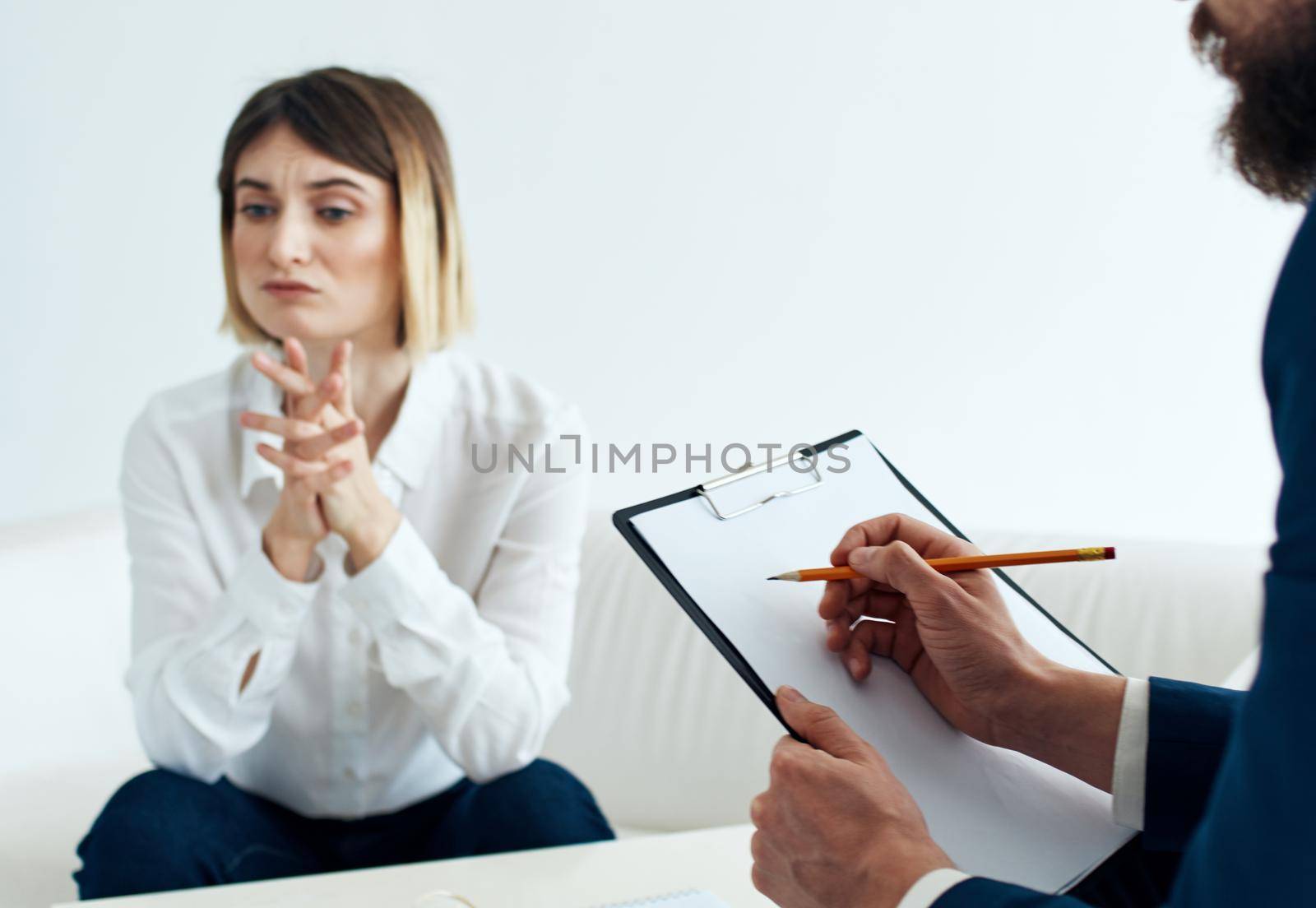 A woman on the sofa of a psychologist at the reception and a man with documents. High quality photo