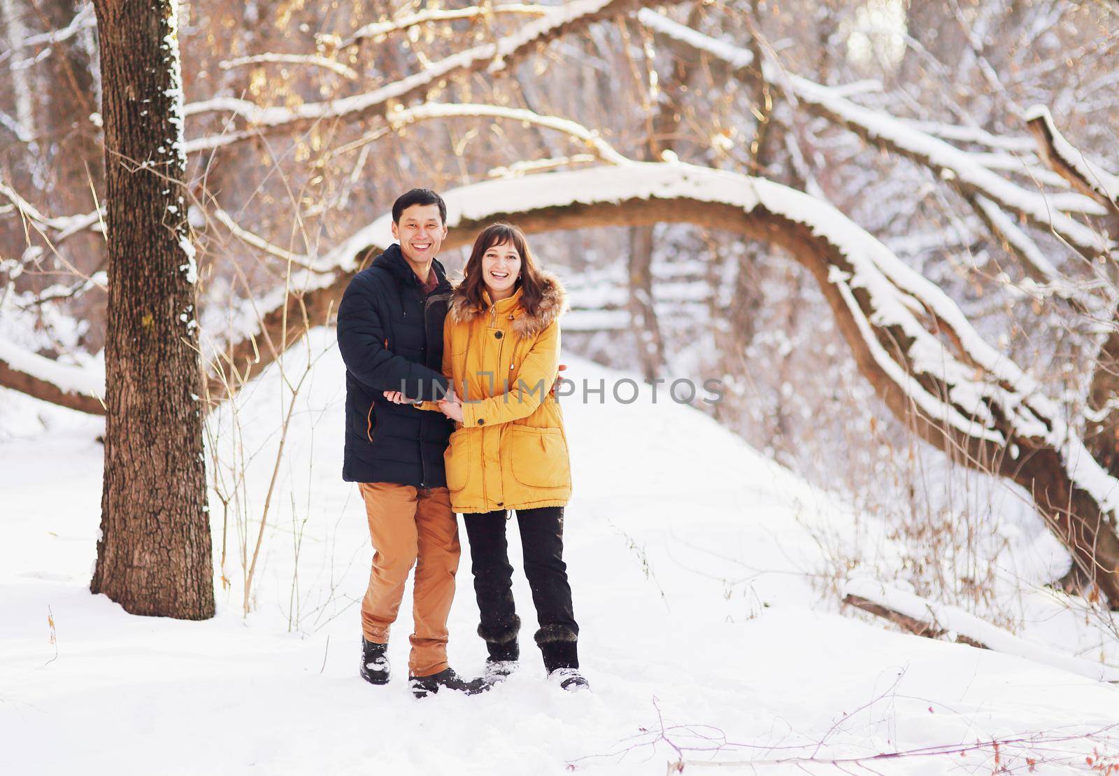 Young couple hug each other in winter in the park by selinsmo