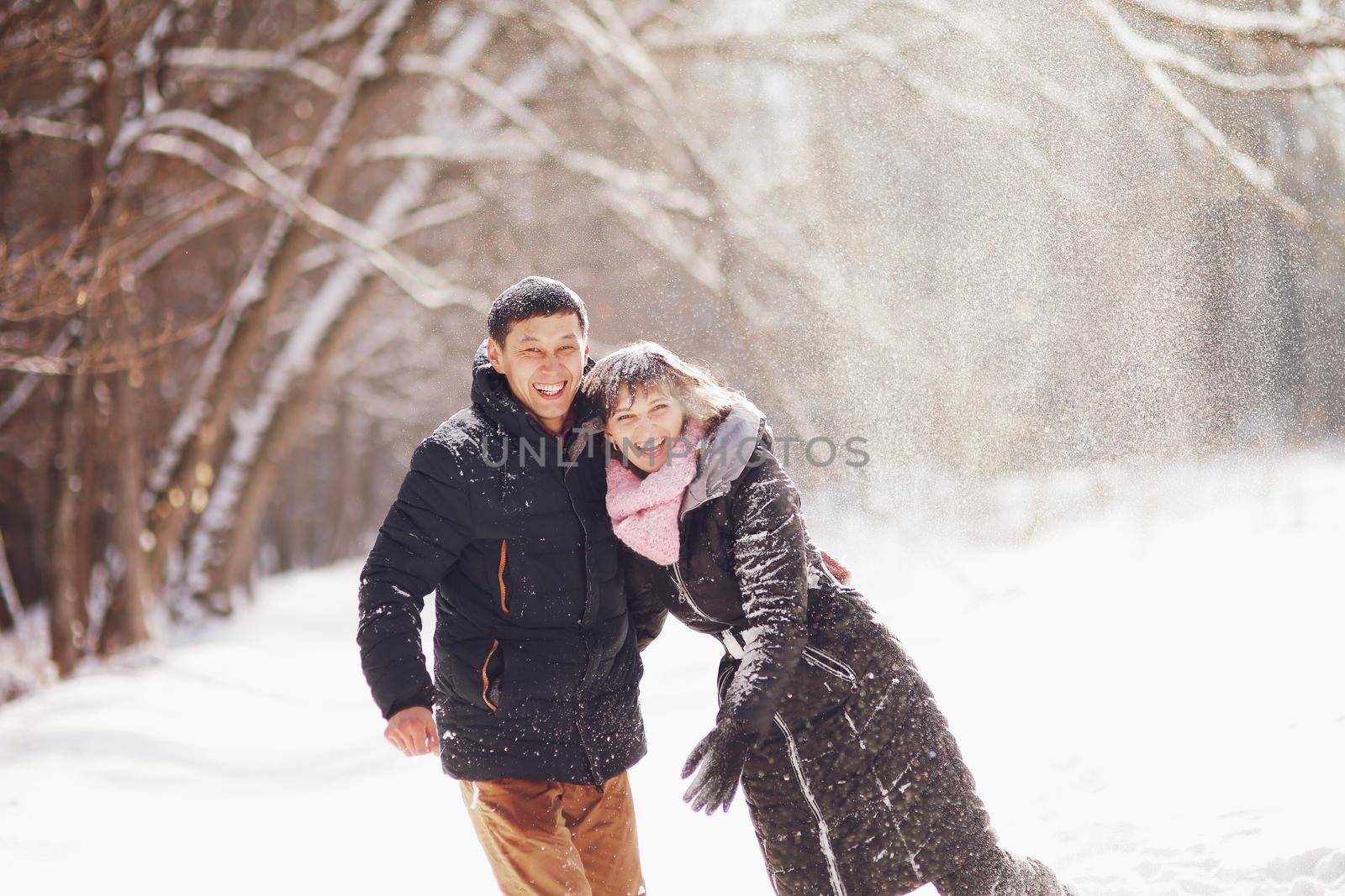 Young couple hug each other in winter in the park. Love story