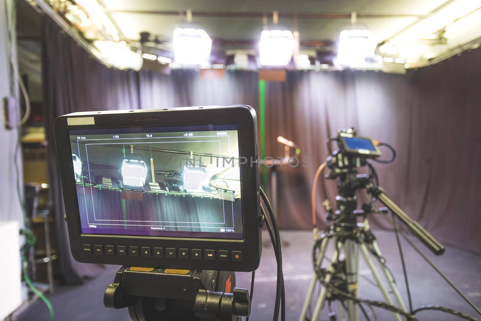 Film camera on a tripod in a television broadcasting studio, spotlights and equipment