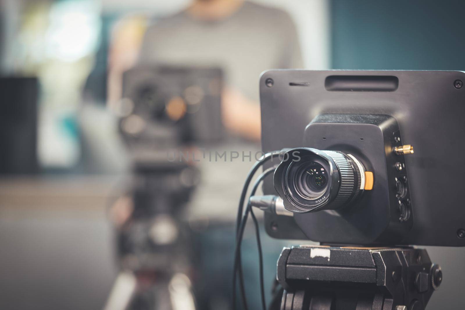 Film camera on a tripod in a television broadcasting studio, spotlights and equipment