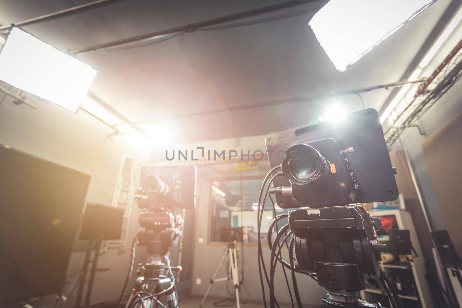 Film camera on a tripod in a television broadcasting studio, spotlights and equipment