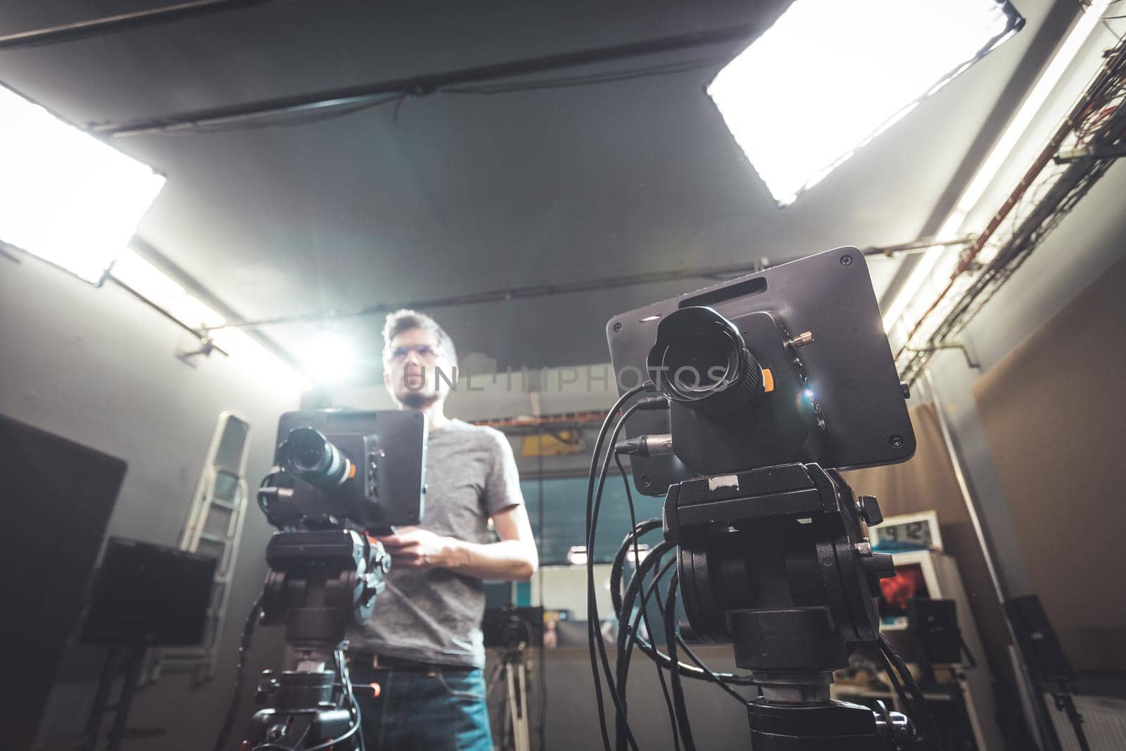 Male cameraman is operating a film camera in a television recording studio