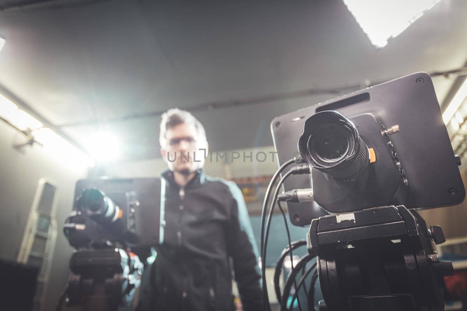 Male cameraman is operating a film camera in a television recording studio