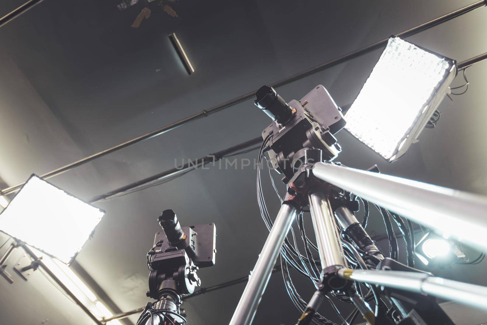 Film camera on a tripod in a television broadcasting studio, spotlights and equipment