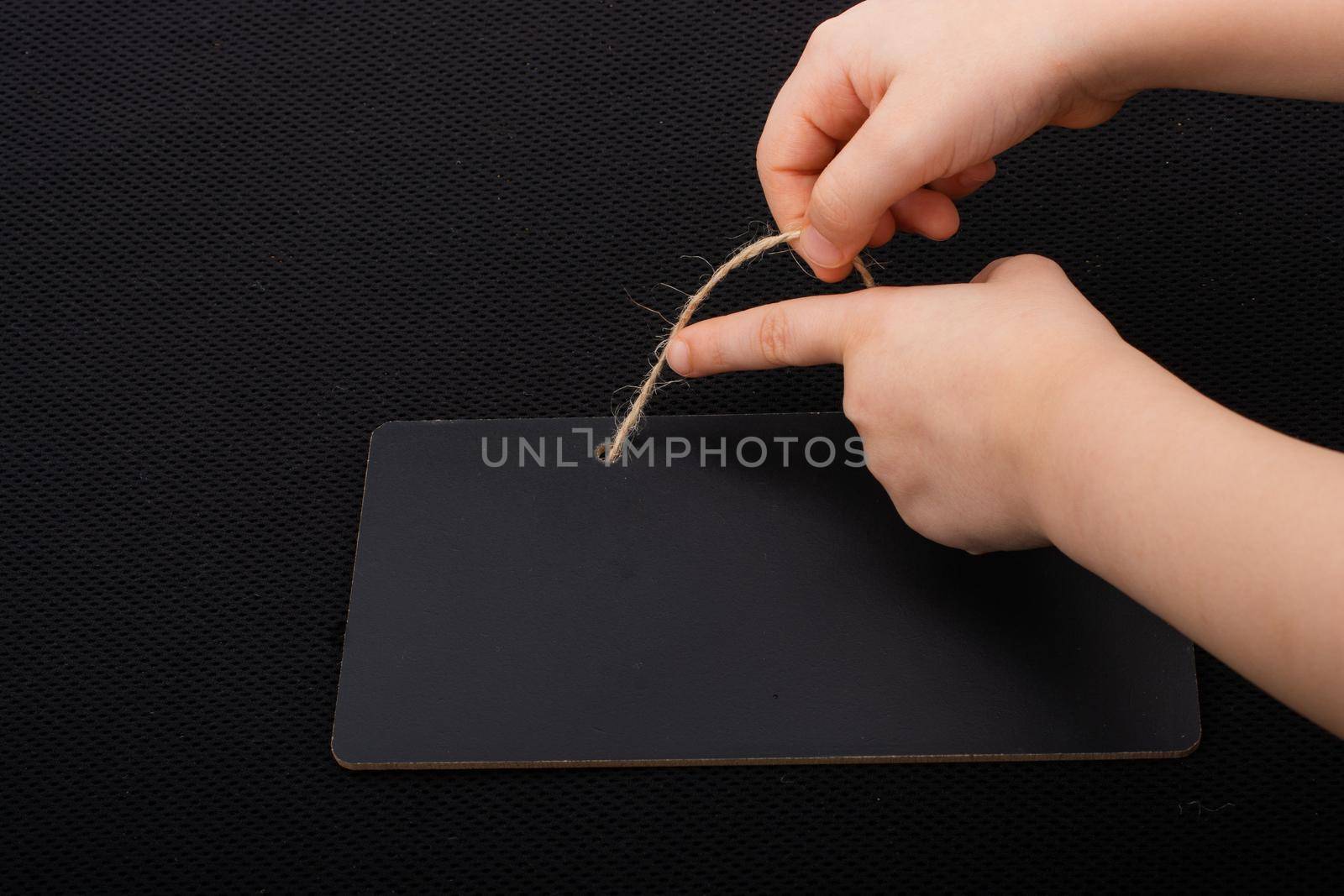 Rectangular shaped black notice board in hand on black background