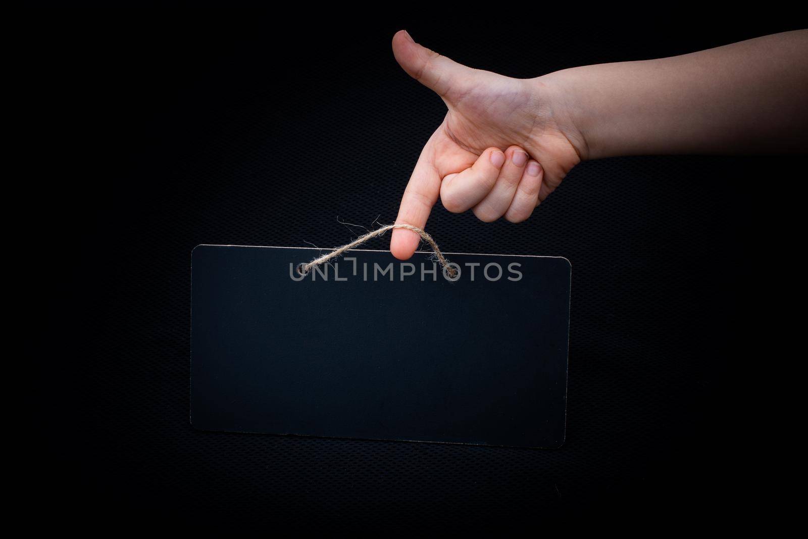 Rectangular shaped black notice board in hand on black background