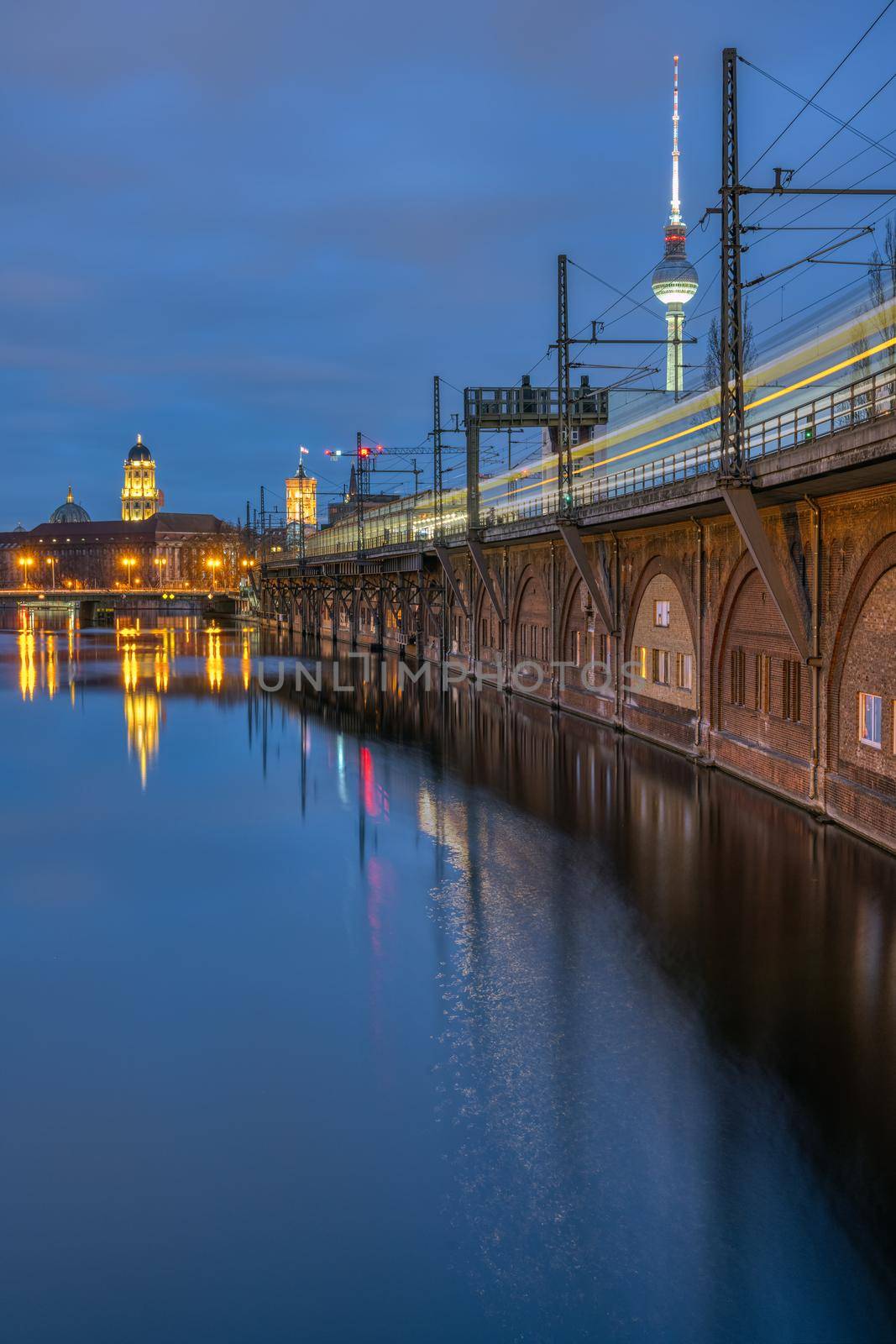 The River Spree, the Television Tower and a moving train in Berlin at dusk