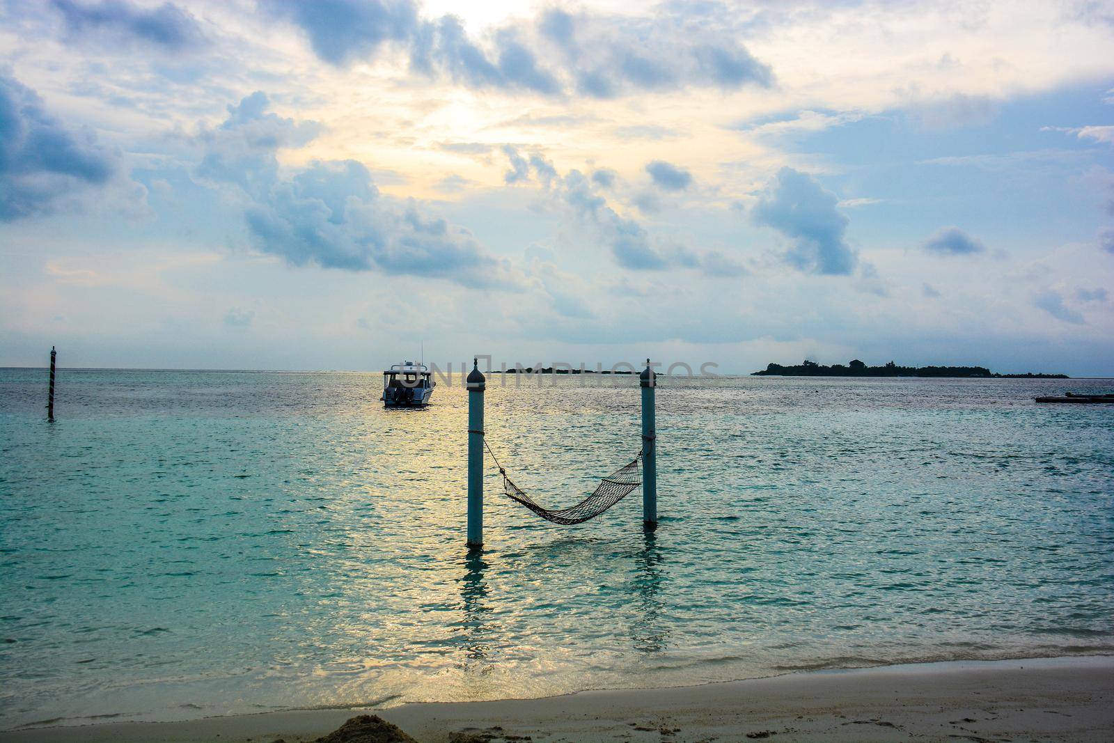 atoll of the tropics and maldives that are reflected in a sea of emerald with a cobalt blue sky