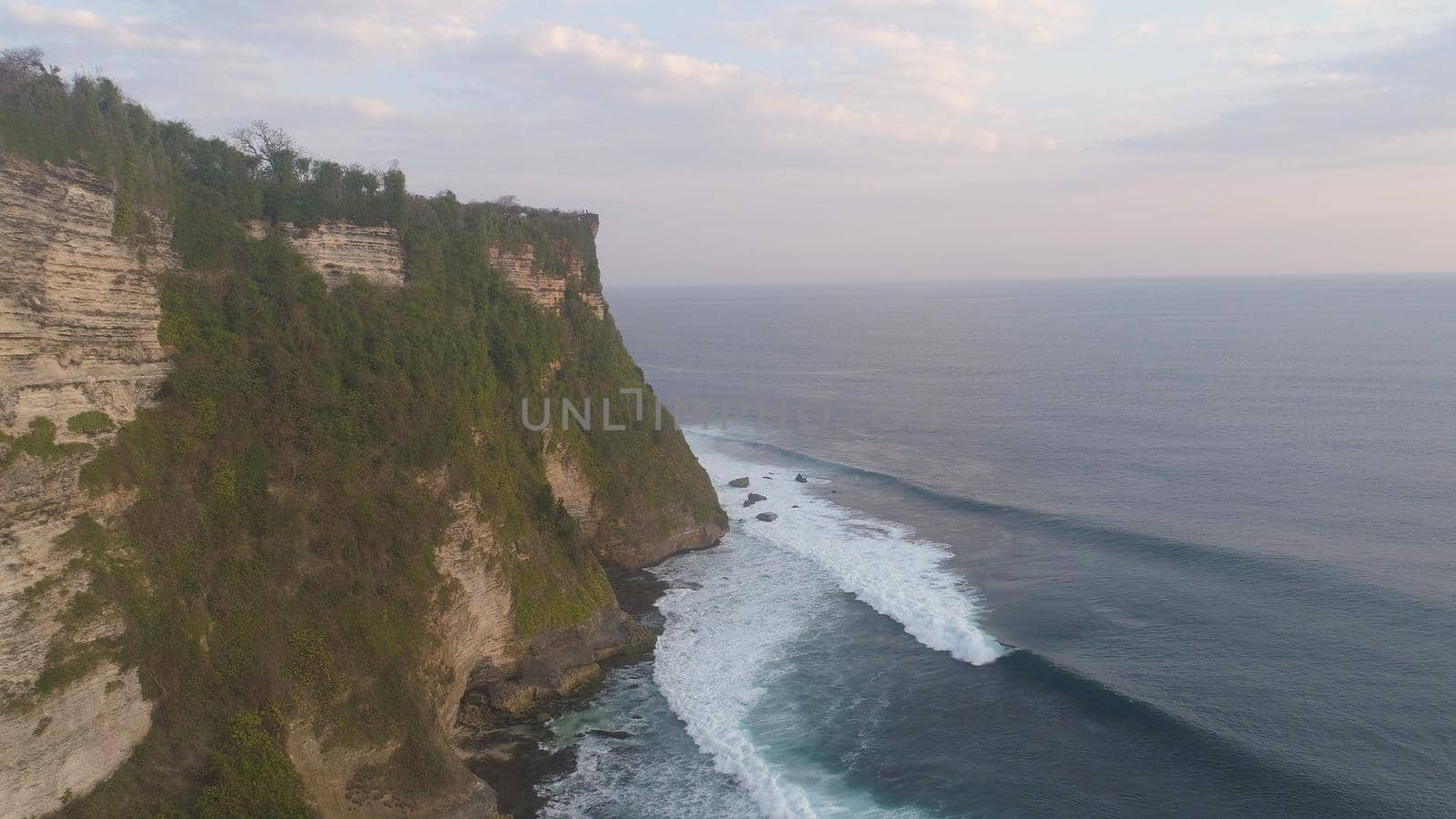 aerial view rocky ocean coastline at sunset. seascape waves break on rocky shore travel concept.
