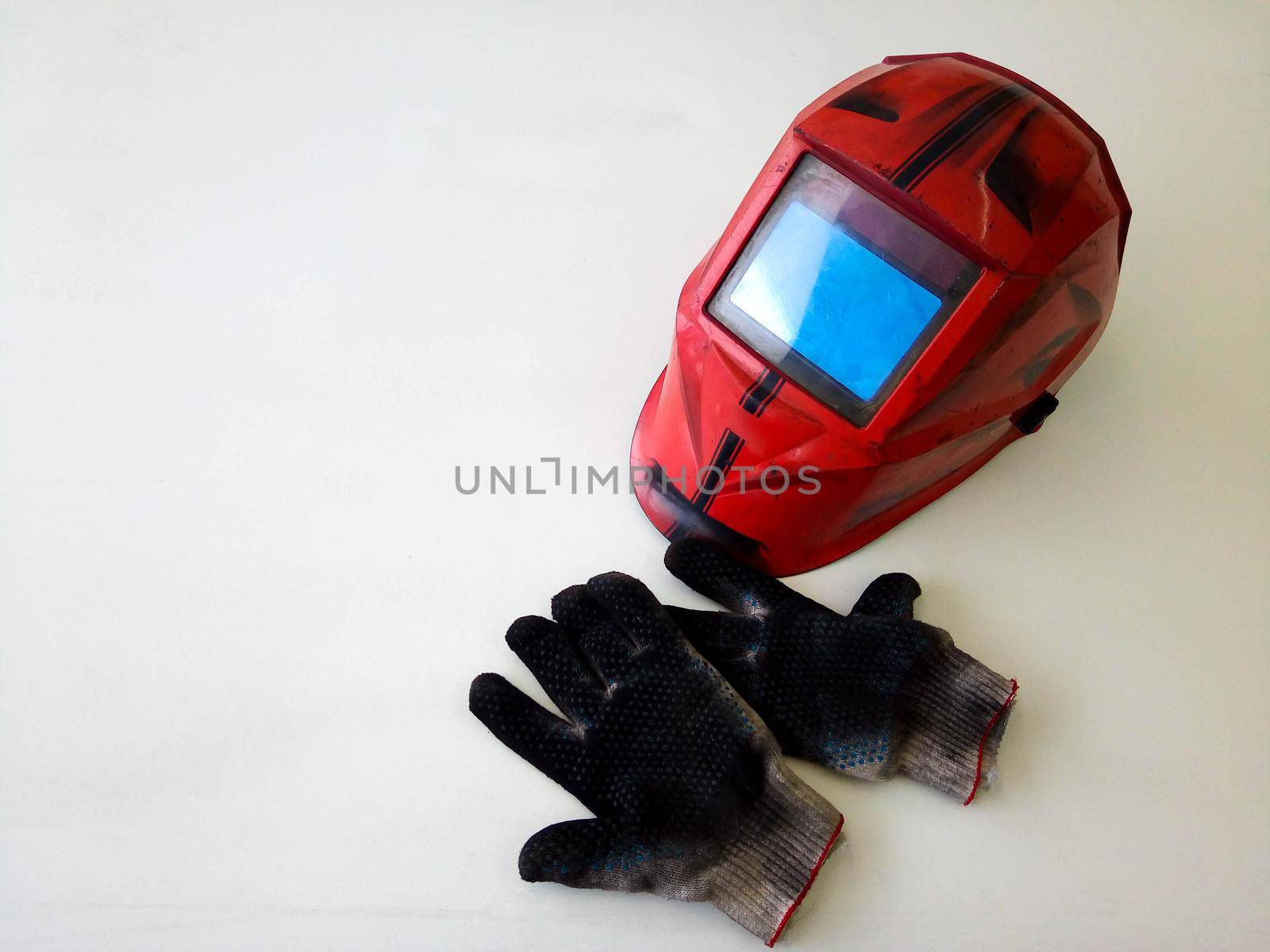 Photos of dirty welding gloves, welder's mask in the workshop.Space for your text. by lapushka62