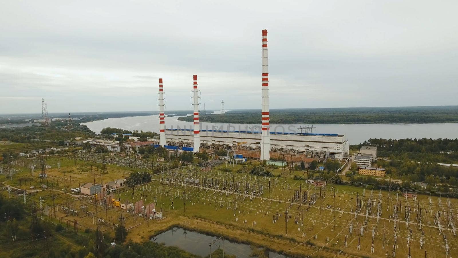 Aerial view Hydroelectric power station, transformation station, cables and wires. High voltage electric power substation. Electrical power transformer in high voltage substation.