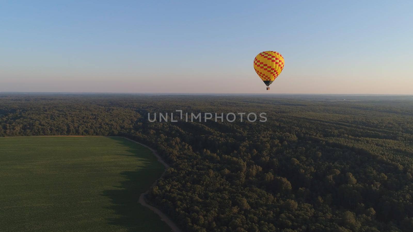 Aerial view Hot air balloons in sky over fields in countryside, beautiful sky and sunset. Aerostat fly over countryside.