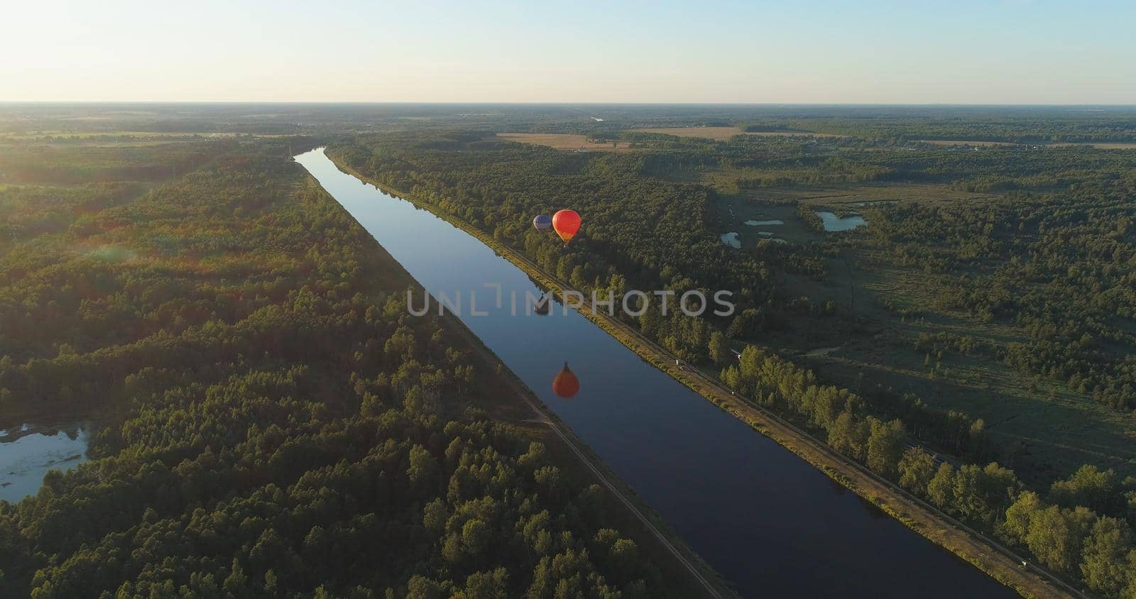 Aerial view Hot air balloons in sky over fields in countryside, beautiful sky and sunset. Aerostat fly over countryside.