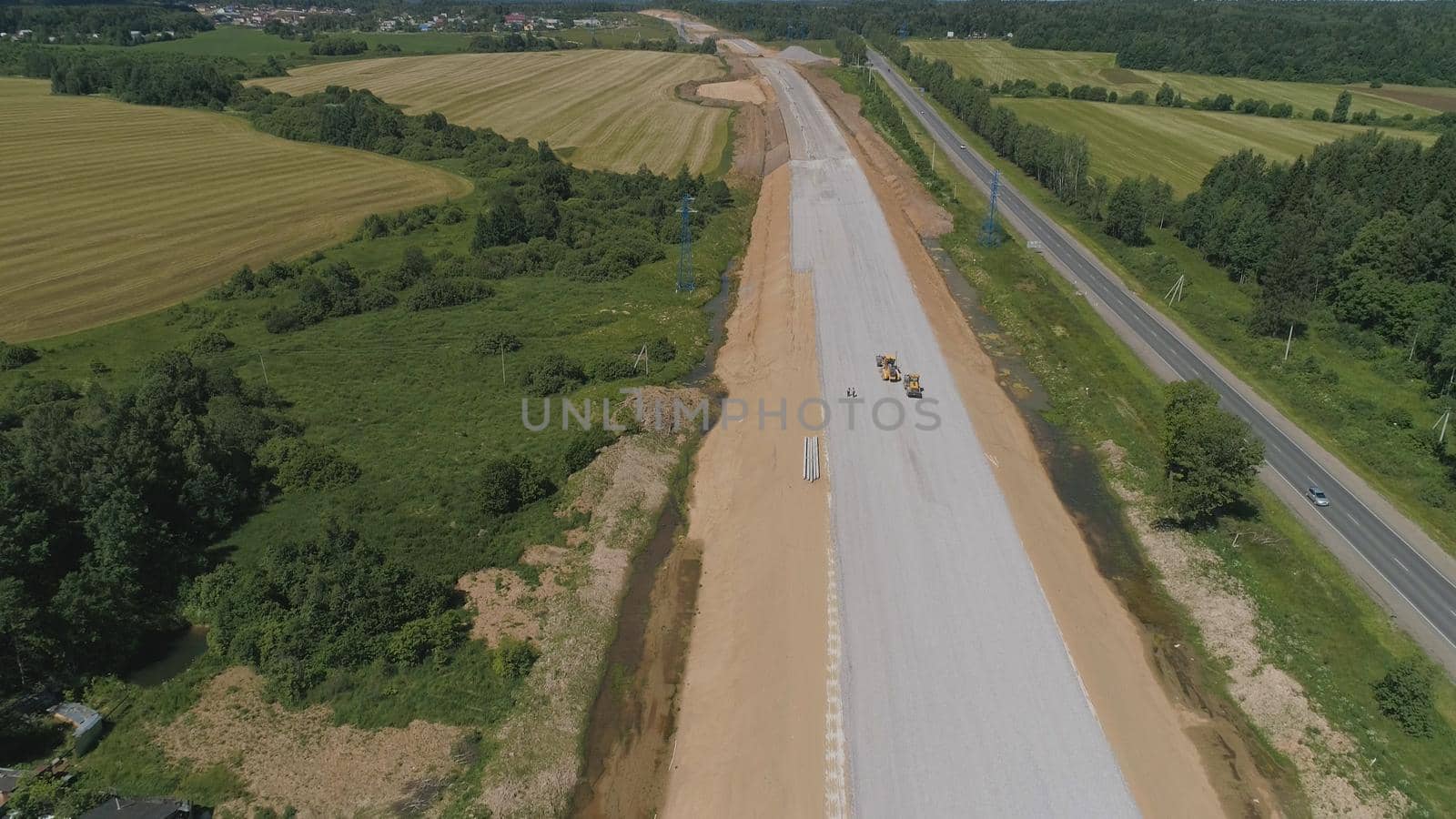 Construction of toll roads in rural areas. Aerial view construction of a new highway next to the old highway.