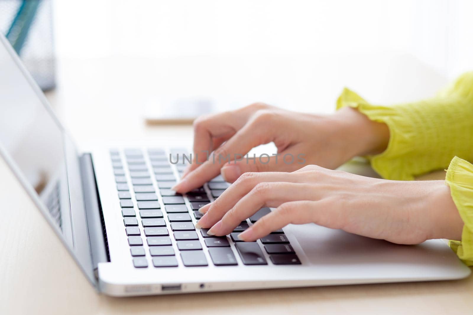 Closeup of hand young asian businesswoman working on laptop computer on desk at home office, freelance looking and typing on notebook on table, woman studying online, business and education concept.