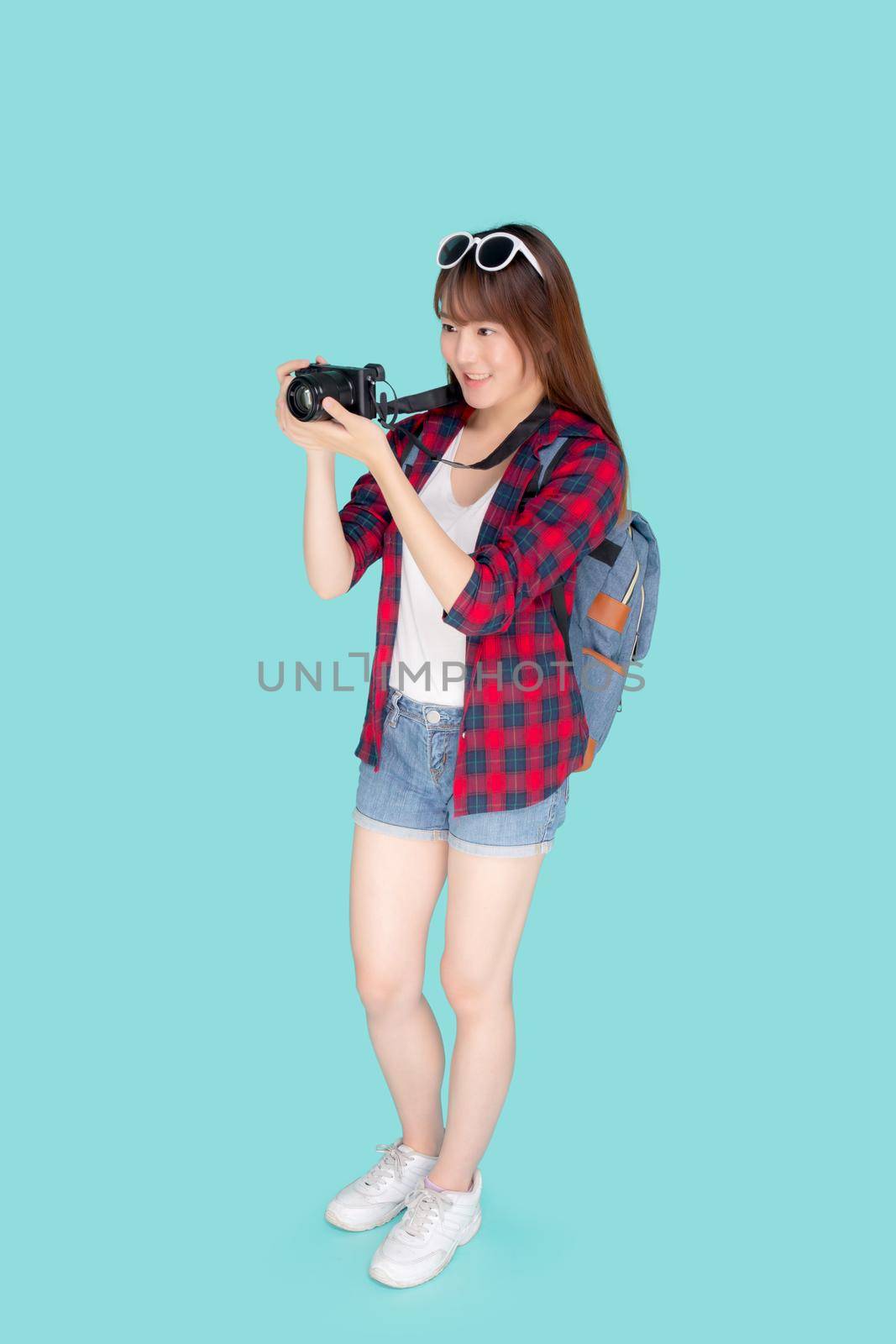 Beautiful young asian woman smiling is journalist photographer wear fashion travel summer, girl holding camera hobby tourist and trip in vacation and holiday isolated on blue background. by nnudoo