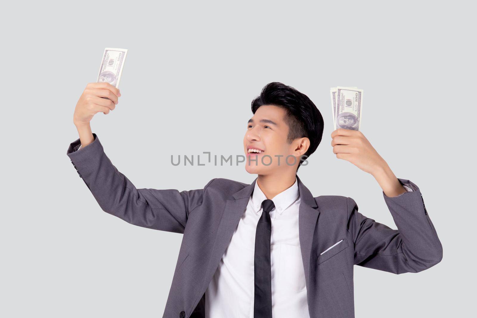 Young asian business man holding money dollar isolated on white background, businessman in suit holding banknote and success and excited with finance, savings and investment, income and spending.