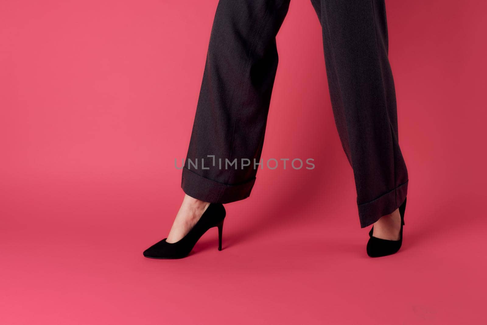 female legs black shoes glamor luxury pink background cropped view. High quality photo