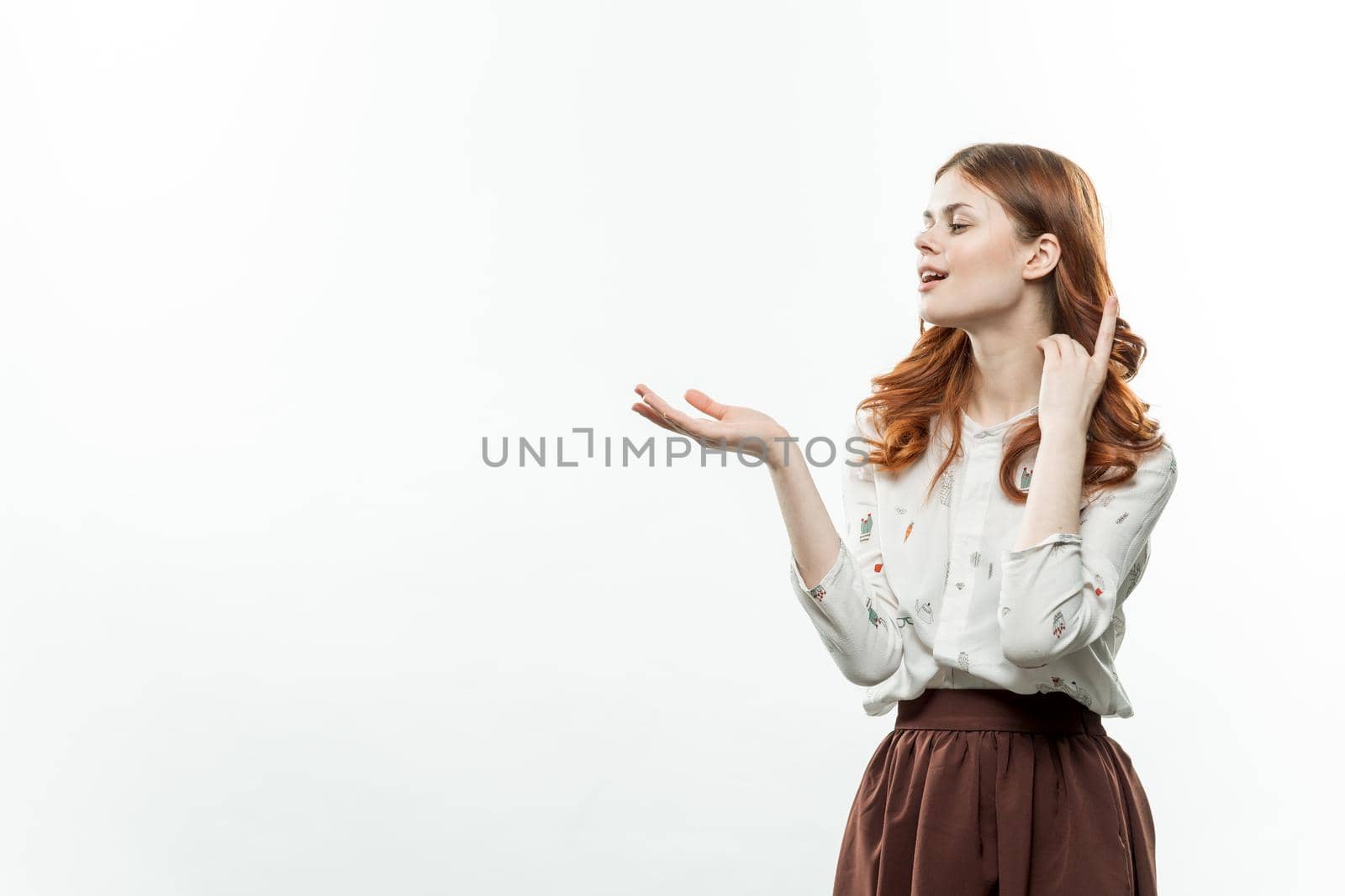 cheerful red-haired woman holding hands in front of her lifestyle Copy Space light background. High quality photo
