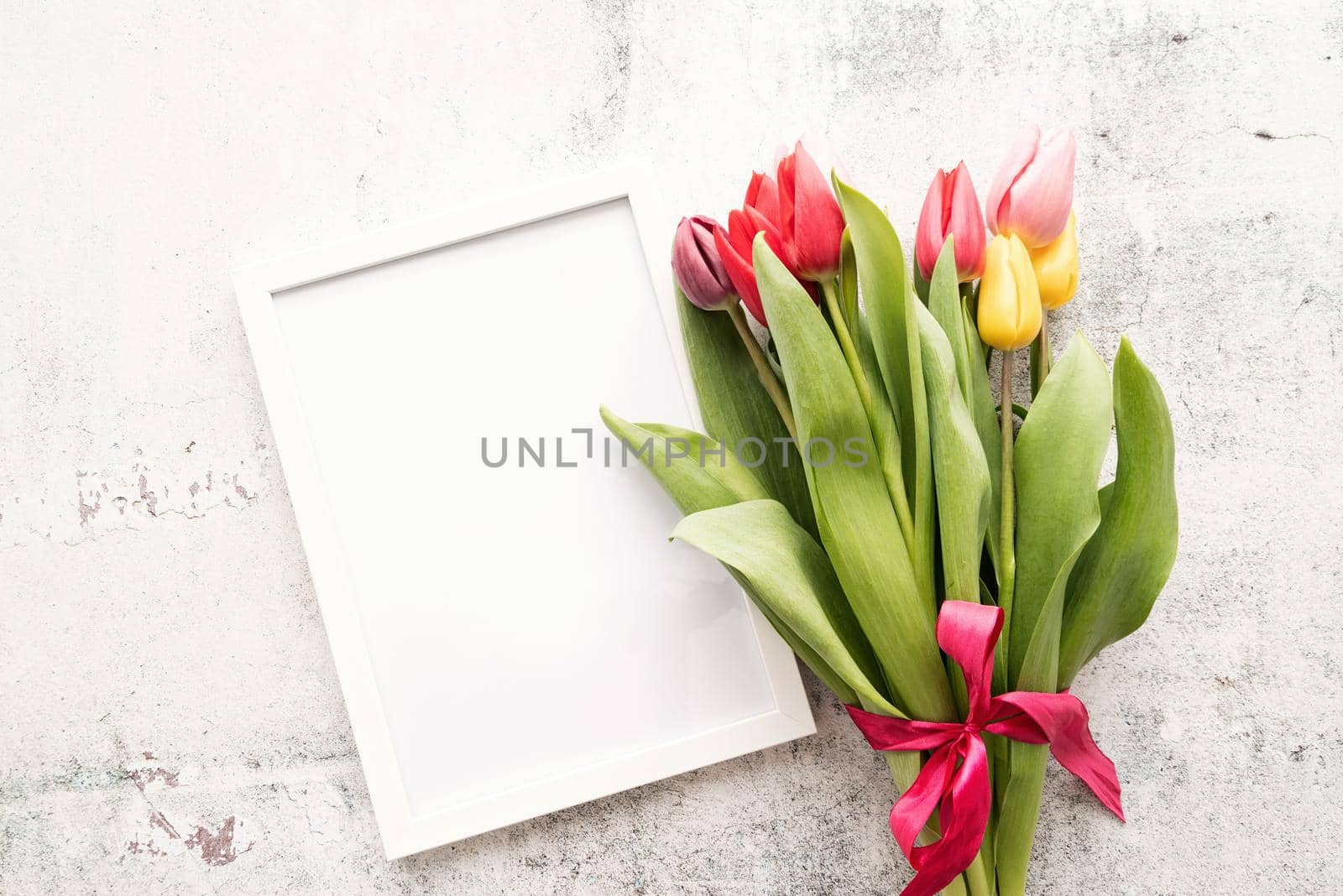 Spring concept. colorfull tulip bouquet and blank frame for mock up design on white background with copy space